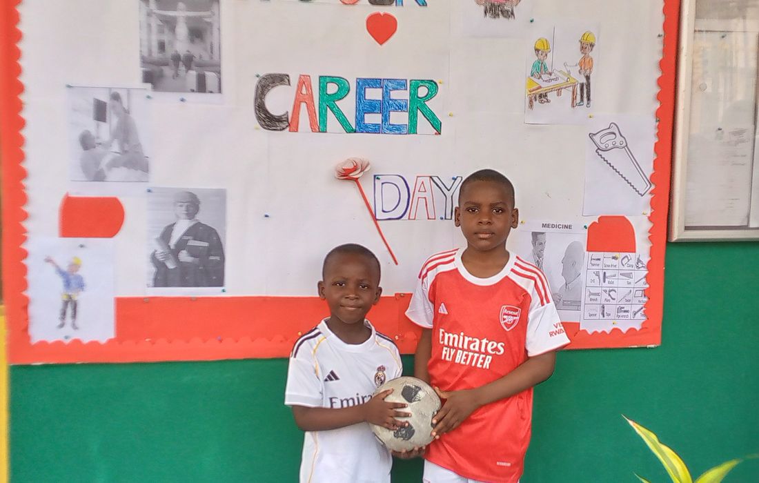 A pupil in football kit holding a ball on Career Day